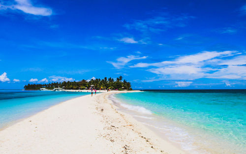 Scenic view of beach against blue sky