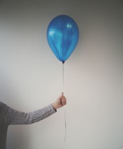 Hand holding balloons against white background