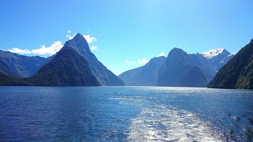 Scenic view of lake and mountains against blue sky