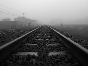 Railroad tracks against sky in foggy weather