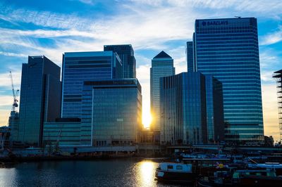 View of skyscrapers in city at sunset