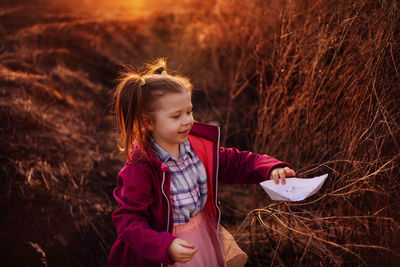 Spring girl with a paper boat