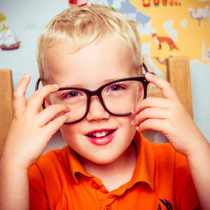 Close-up portrait of smiling boy wearing eyeglasses