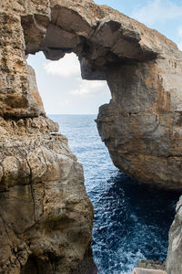 Wied il mielah canyon and natural arch over the sea in gozo, malta