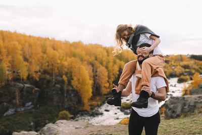 Happy people in love are travel hike in nature in the autumn forest. romantic trip to countryside