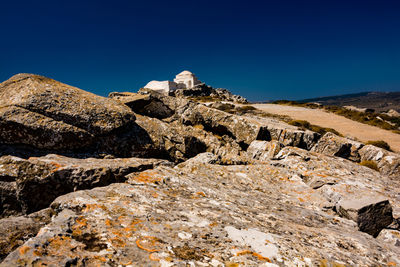 Low angle view of rocks against blue sky