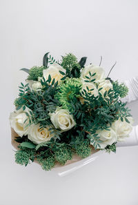 Girl holds bouquet of white roses