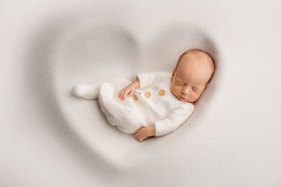 Close-up of baby boy sleeping on bed