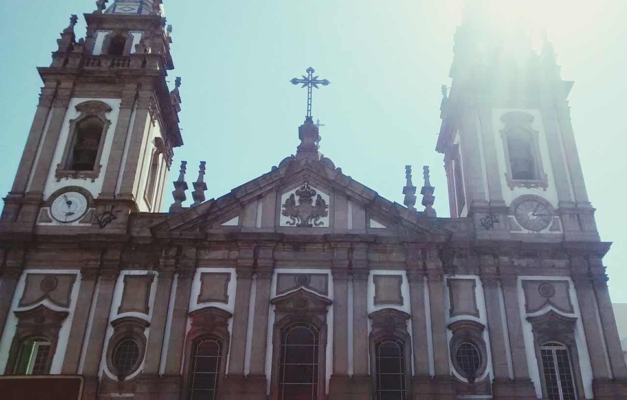 religion, church, place of worship, architecture, building exterior, spirituality, low angle view, built structure, cathedral, clock, cross, clock tower, sky, travel destinations, famous place, clear sky, tower, high section