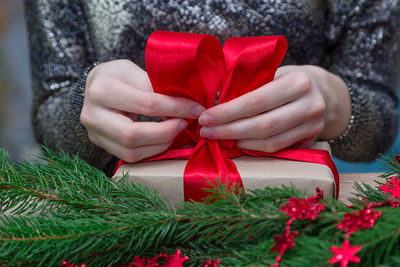 Midsection of woman with packing christmas present on table