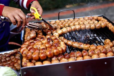 Cropped hand preparing food on barbecue grill