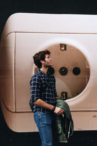 Rear view of young woman standing against wall