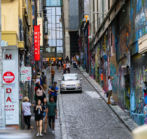 People on street amidst buildings in city