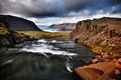 Scenic view of waterfall against sky