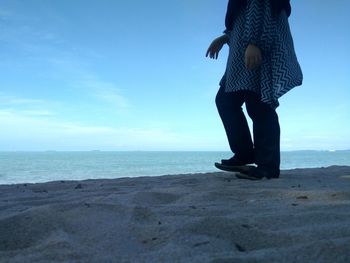 Low section of person standing on beach