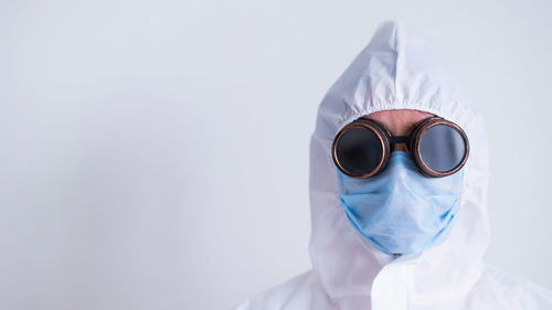 Portrait of person wearing mask against white background