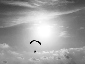 Low angle view of person paragliding against sky