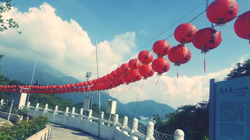 Low angle view of lanterns hanging against sky