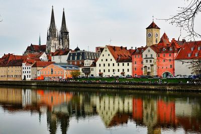 Reflection of regensburg cathedral and buildings on danube river