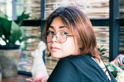 Close-up portrait of young woman in cafe