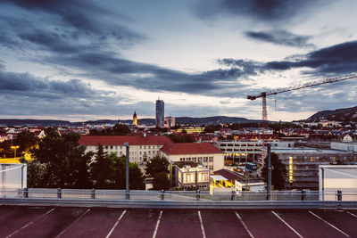 High angle view of city buildings against cloudy sky