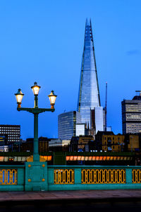 Modern buildings in city against blue sky