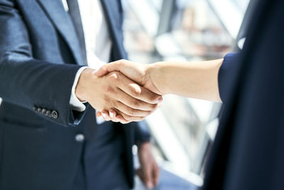 Close-up of handshake of businesswoman and businessman