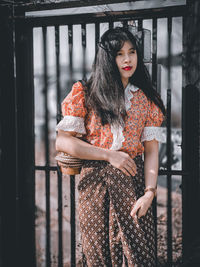 Portrait of woman standing by railing