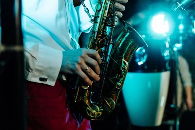 Midsection of man playing saxophone