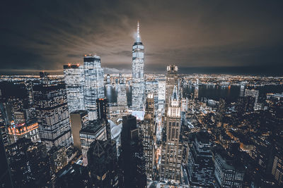 Illuminated buildings in city against sky