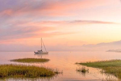 Sailboat on sea against sky during sunset