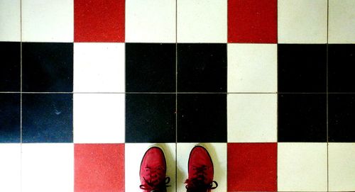 Low section of man standing on tiled floor