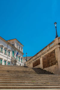 Low angle view of steps against clear blue sky