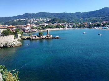 Townscape by sea against clear blue sky