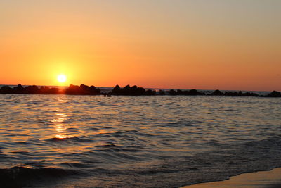 Scenic view of sea against orange sky