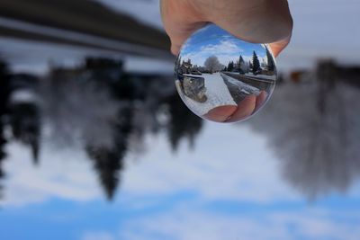 Cropped hand holding crystal ball with reflection