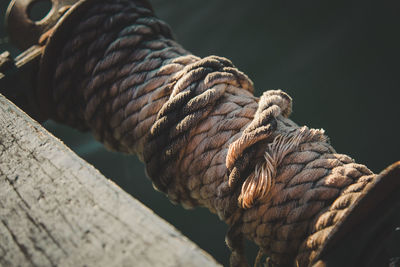 Close-up of rope rolled up on pulley at lake