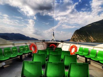 View of empty chairs against cloudy sky