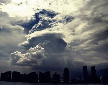 Silhouette buildings in city against sky