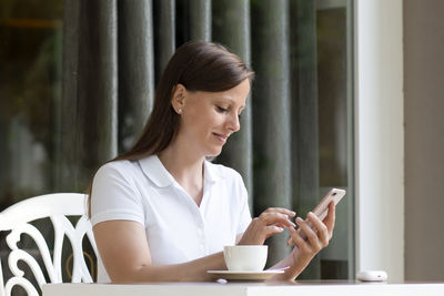 Young woman using mobile phone at home