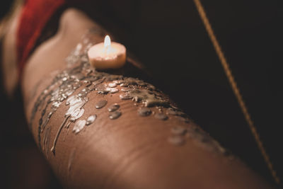 Close-up of glowing candle at temple