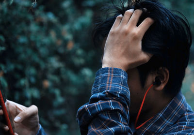 Close-up of man using smart phone in forest