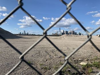 Scenic view of landscape seen through chainlink fence