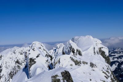 Scenic view of snowcapped mountains against clear blue sky