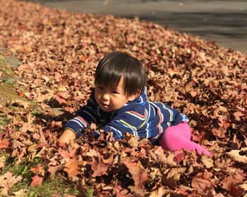 Portrait of girl playing leaves during autumn