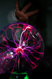 Close-up of hand holding illuminated flower