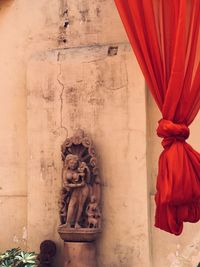 Statue of buddha against wall in building