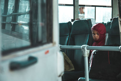 Portrait of woman looking through window