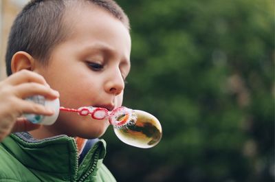 Close-up of boy blowing bubbles