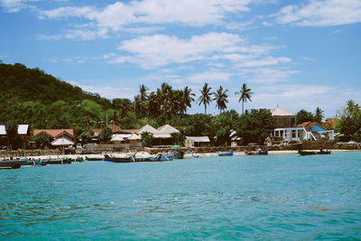 Houses by sea against sky